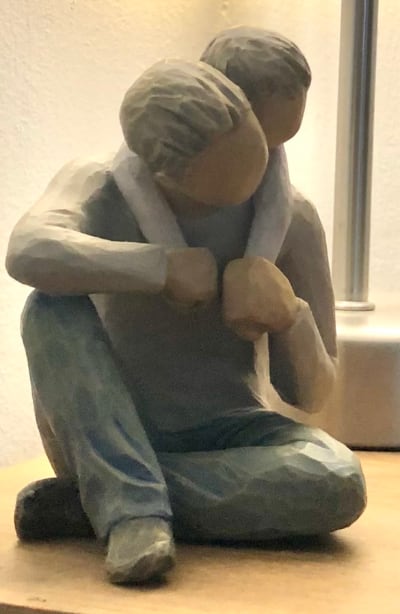 A rough statue of a father playing with his son.